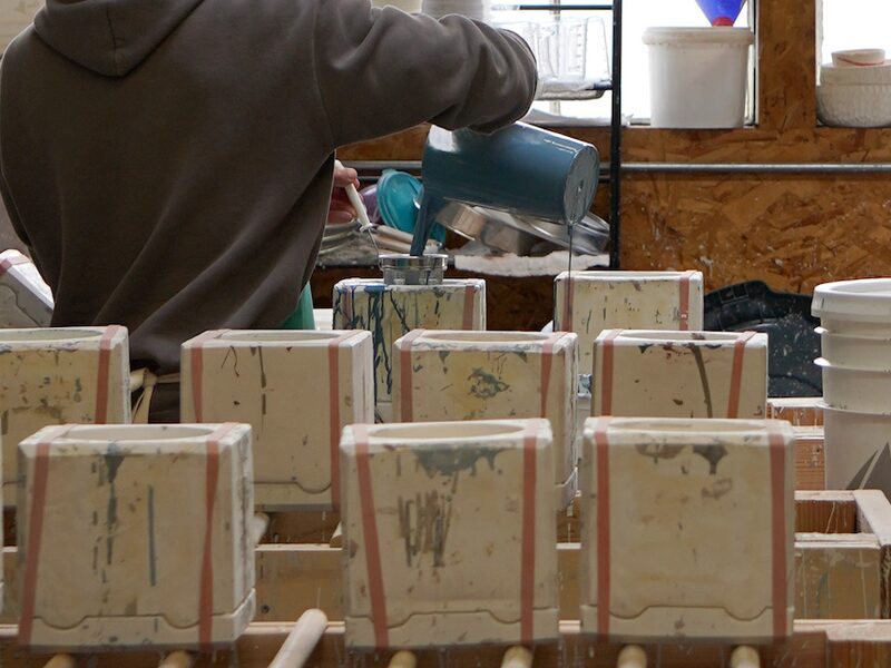The Schiller CW shop floor: slip being poured into a row of ceramic moulds.
